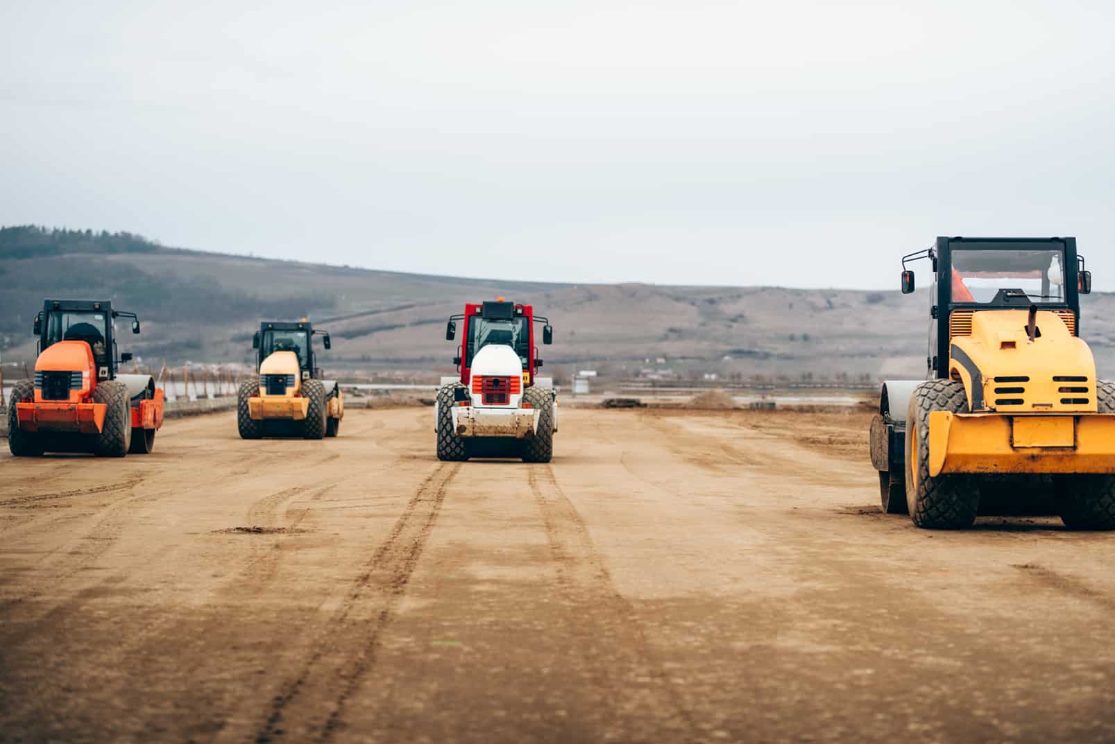 Vibratory Compactor during road and highway construction. Industrial roadworks with heavy-duty machinery with a goal towards economic development